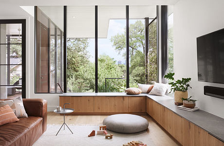 Modern living room with large windows, wooden accents, and minimalist furniture.