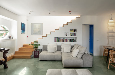 Modern living room with floating staircase and minimalist decor.