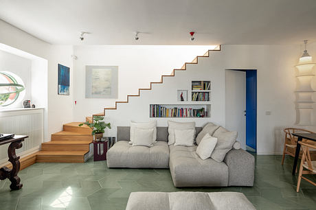 Modern living room with floating staircase and minimalist decor.