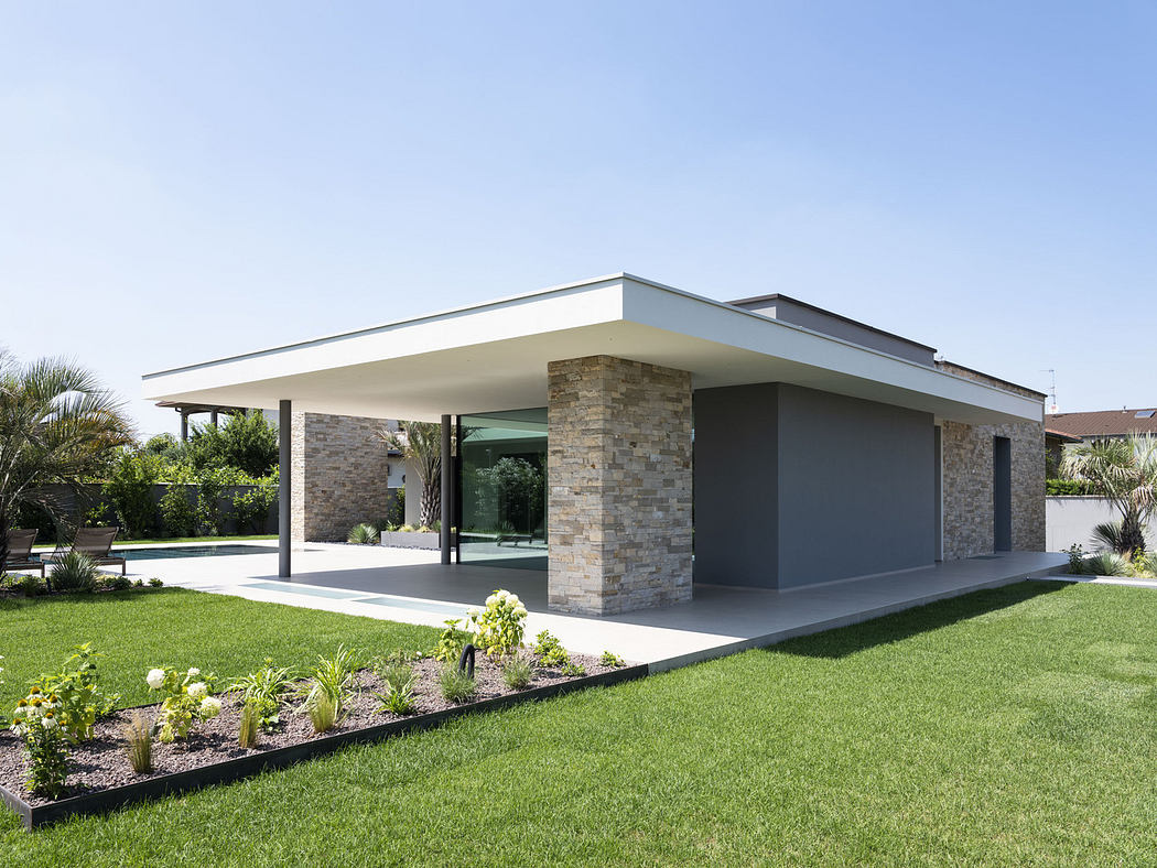 Modern single-story house with a flat roof and stone accents.