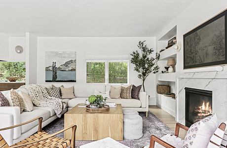 Bright living room with white sofa, fireplace, and modern decor.