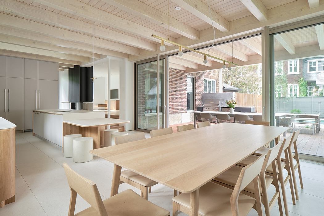 Modern kitchen with wooden table, chairs, and exposed ceiling beams.