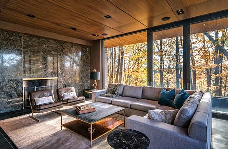 Modern living room with large windows, a sectional sofa, and wooden accents.