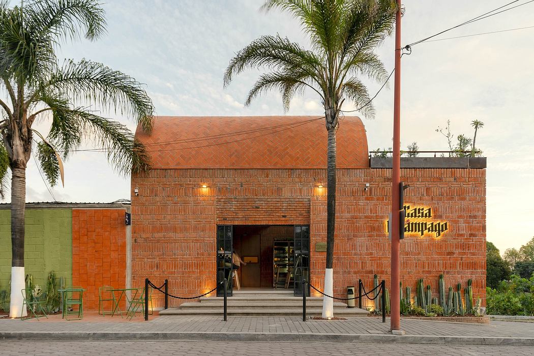 Modern brick building with large entrance and palm trees.