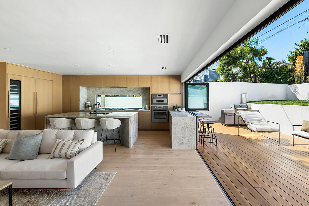 Modern open-plan living space with kitchen, living area, and outdoor deck.
