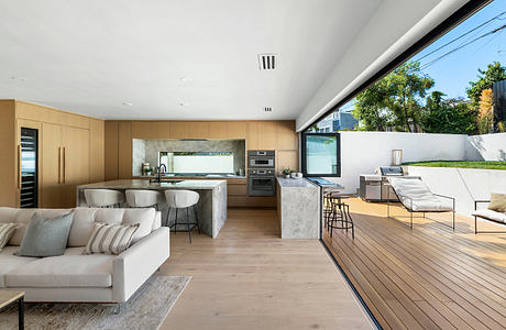 Modern open-plan living space with kitchen, living area, and outdoor deck.