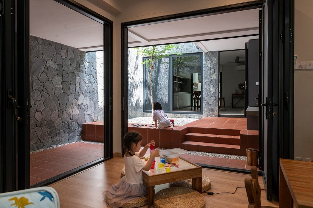 Modern indoor-outdoor space with child playing and sliding doors.