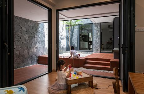 Modern indoor-outdoor space with child playing and sliding doors.