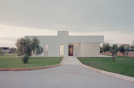 Modern single-story building with a patterned facade and central walkway.