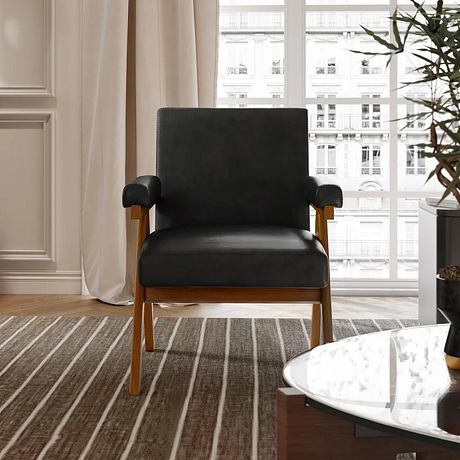 Modern black chair in a minimalist room with striped rug and large window.
