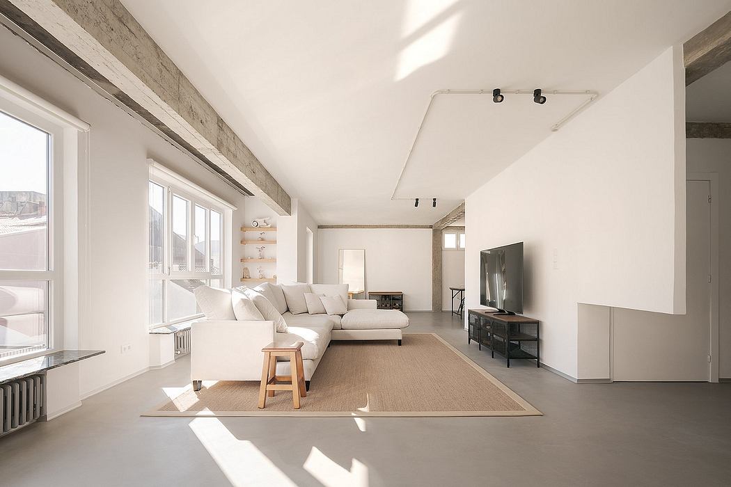 Minimalist living room with white walls, exposed beams, and large windows.
