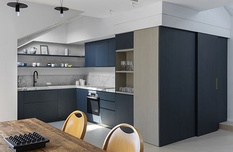 Stylish kitchen with navy cabinets and marble backsplash.