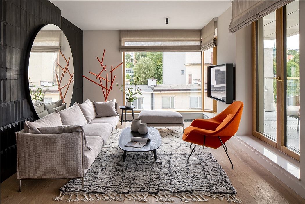 Modern living room with a gray sofa, orange chair, and large windows.