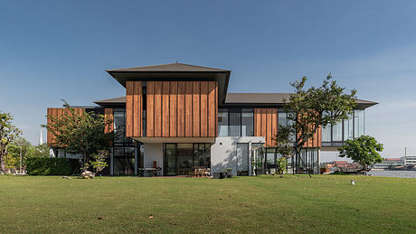 Modern two-story building with large windows and wooden slats façade.