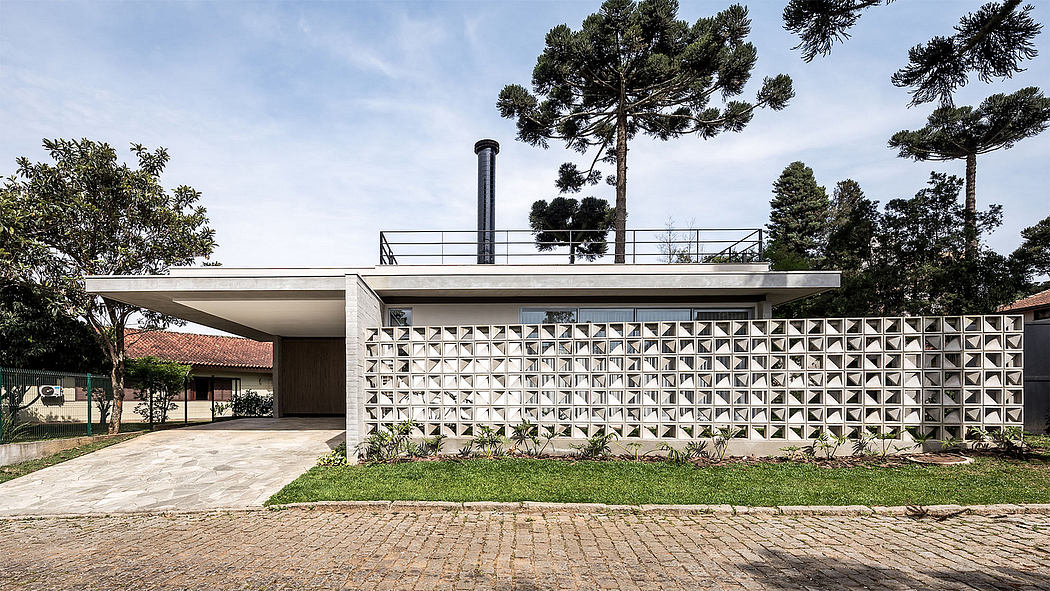 Contemporary house with patterned concrete wall and flat roof.