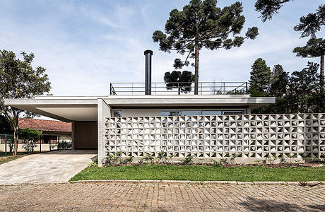 Contemporary house with patterned concrete wall and flat roof.