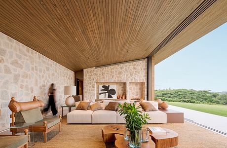 Contemporary living room with stone walls and wooden ceiling.