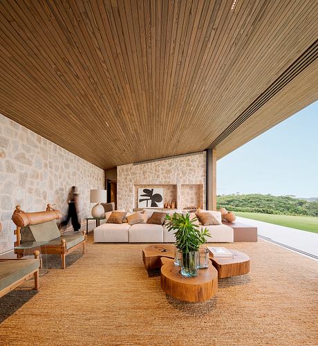 Contemporary living room with stone walls and wooden ceiling.