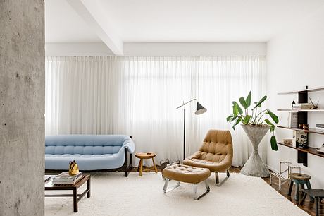 Modern living room with minimalist furniture and white curtains.