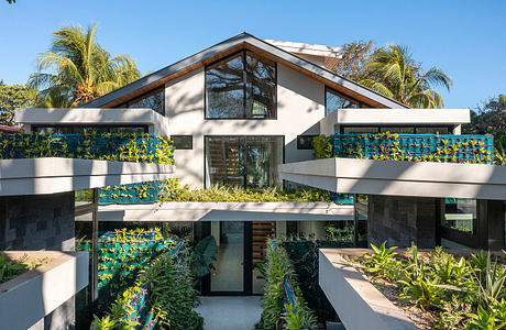 Modern home with geometric design and green plant balconies.