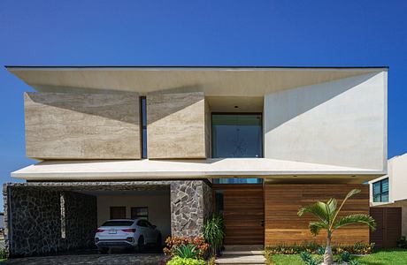 Contemporary house with geometric facade and carport.