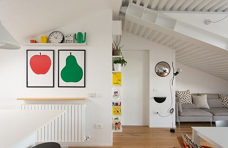 Modern interior with staircase, framed art, and a cozy sitting area.