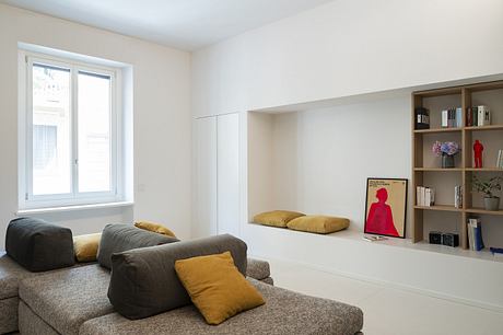 Minimalist living room with built-in shelving and neutral tones.