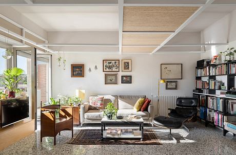 Contemporary living room with exposed beams, bookshelves, and cozy furnishings.