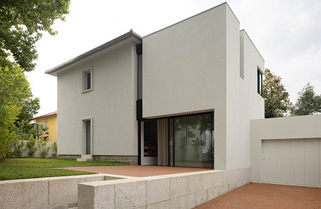 Modern two-story house with clean lines, large windows, and a small front yard