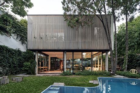 Contemporary two-story house with wooden slats over glass and pool.