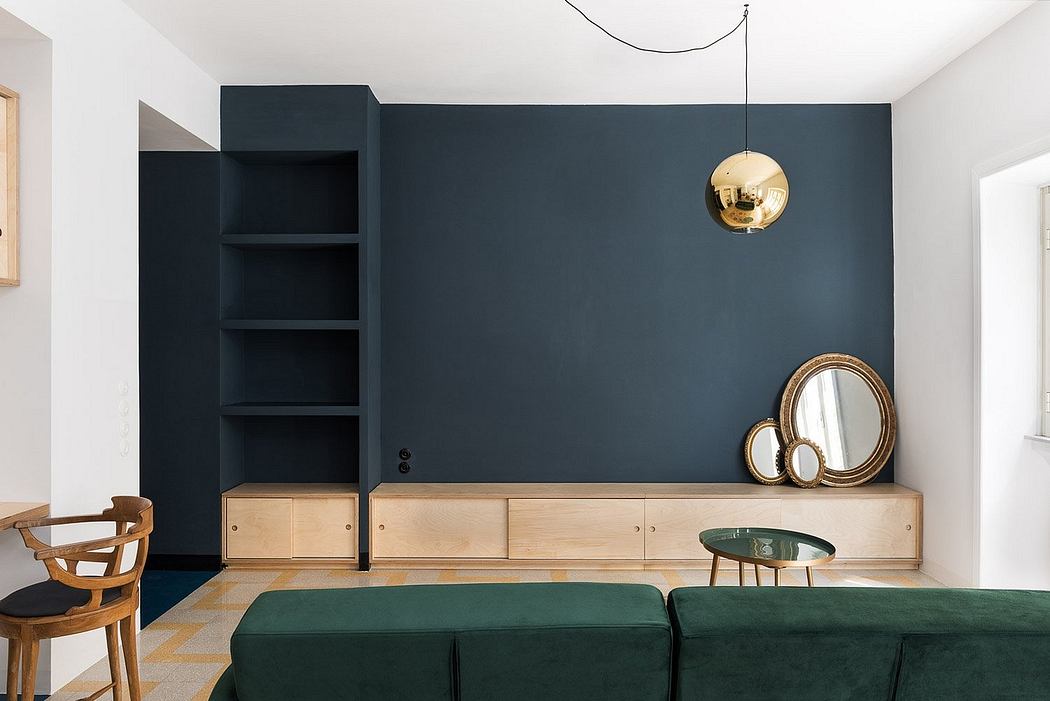 Contemporary room with navy wall, wooden accents, and gold pendant light.