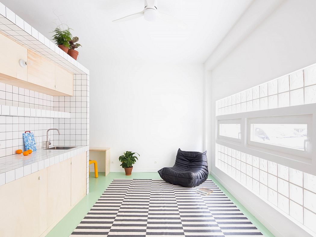 Bright minimalist kitchen with striped floor and bean bag chair.