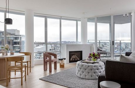 Sleek living space with large windows, city view, and minimalist decor.