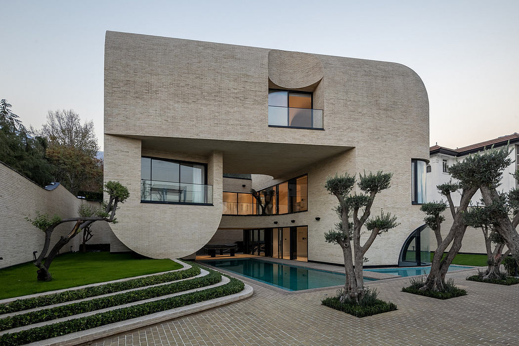 Curvilinear facade house with pool and garden.