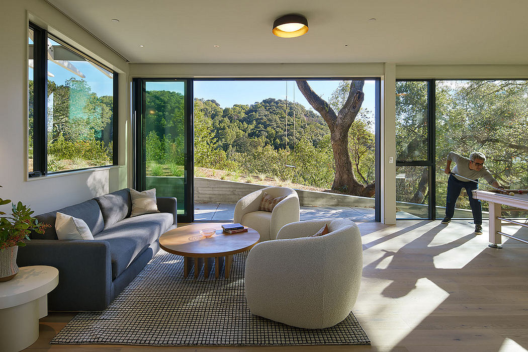 Modern living room with large windows and nature view.