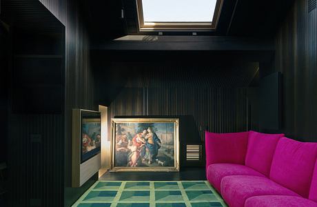 Sleek interior with bold pink sofa, classic painting, and geometric rug.