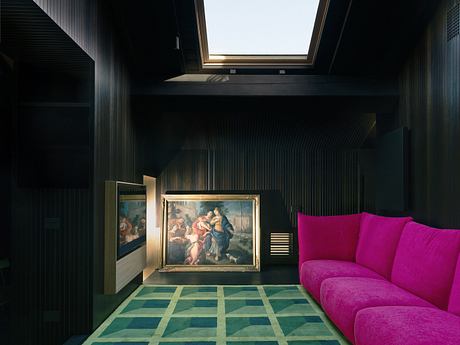 Sleek interior with bold pink sofa, classic painting, and geometric rug.