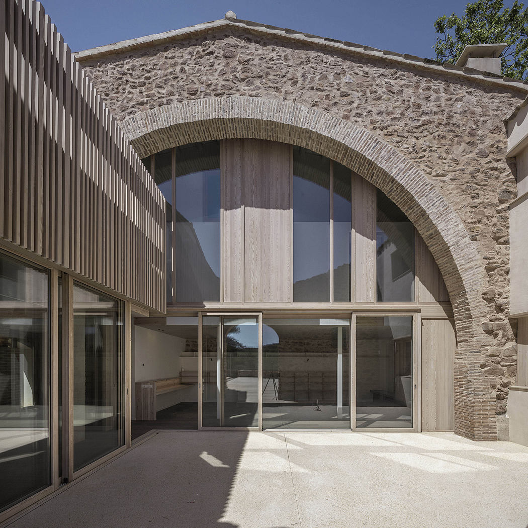 Contemporary stone building with large glass windows and wooden accents.