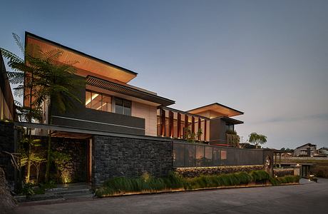 Contemporary house with geometric lines and warm lighting at dusk.