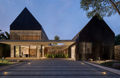 Modern house with geometric design and illuminated interiors at dusk.