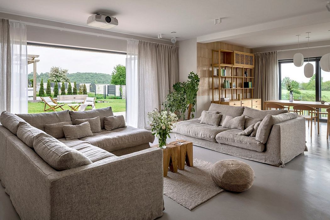 Contemporary living room with neutral tones and large windows.
