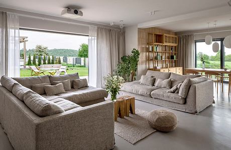 Contemporary living room with neutral tones and large windows.