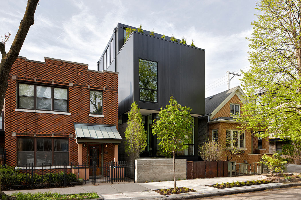 Contemporary black and brick buildings amidst traditional homes.