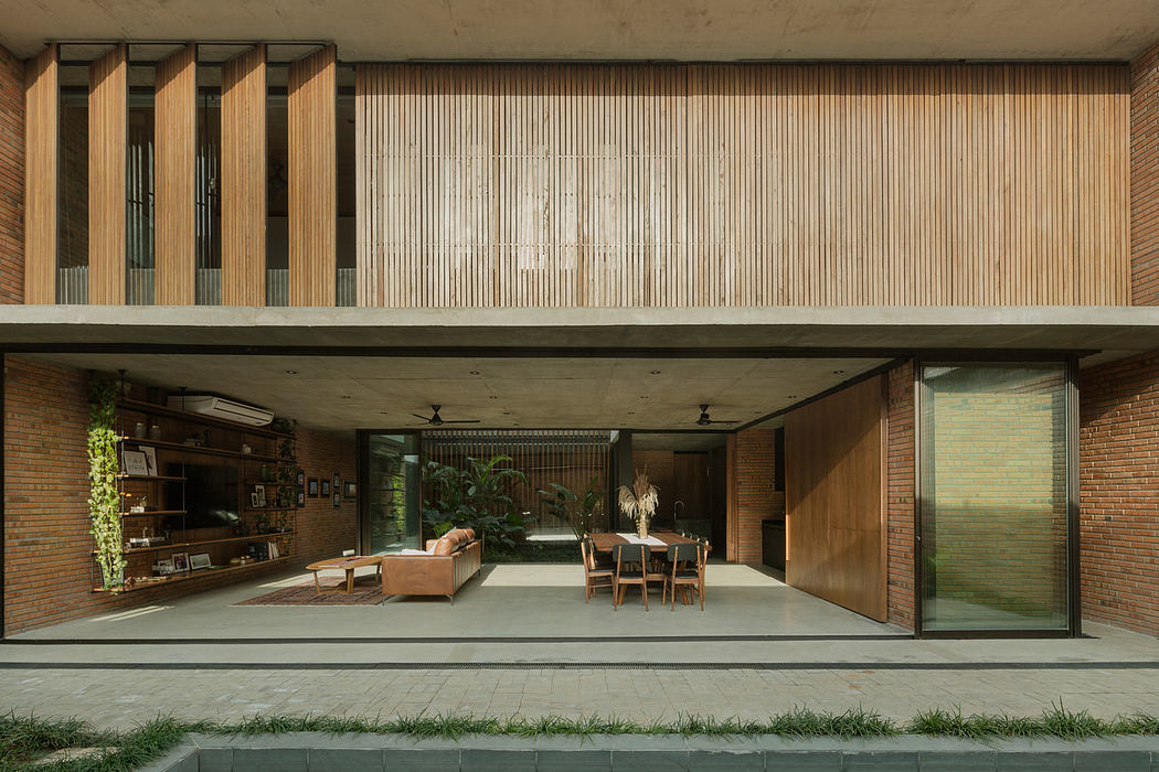Modern house with open-plan living area, wooden slats, and concrete exterior.