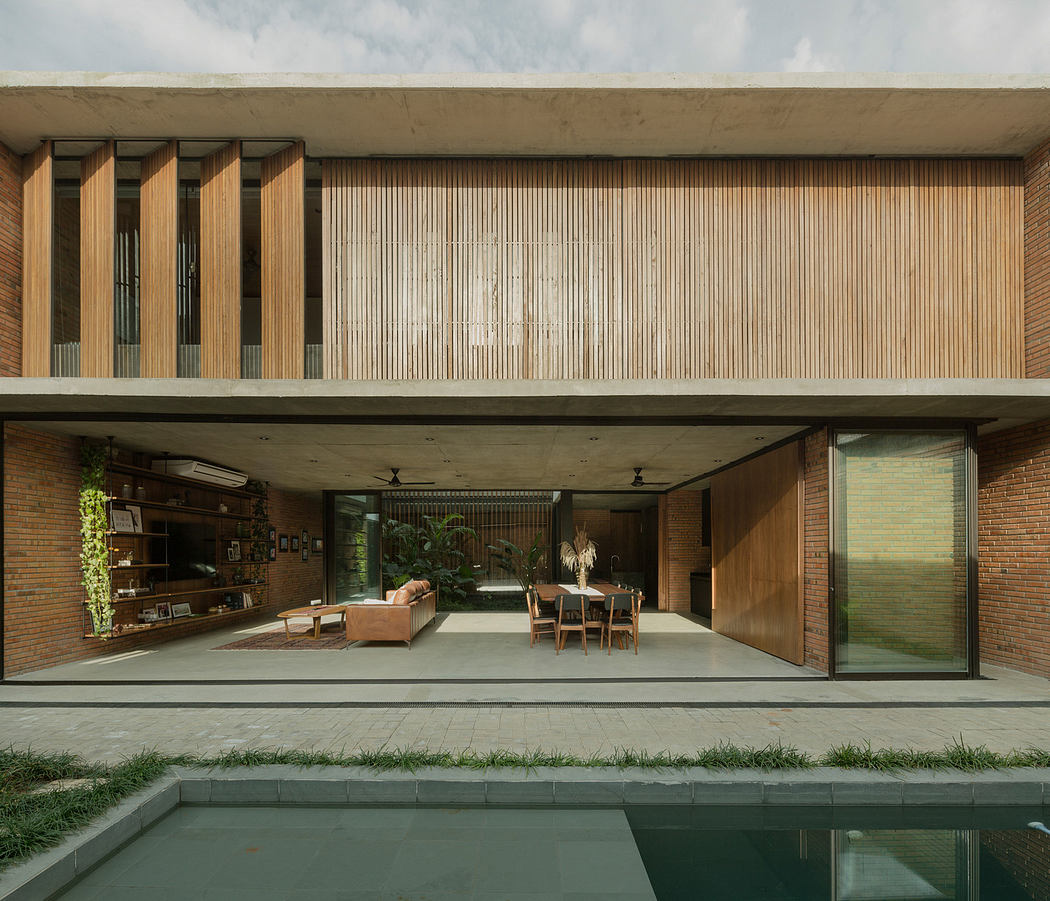 Modern house with open-plan living area, wooden slats, and concrete exterior.