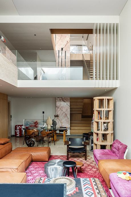 Modern multi-level living room with colorful furniture and a staircase.