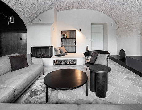 Modern living room with arched ceiling, gray tones, fireplace, and sleek furniture