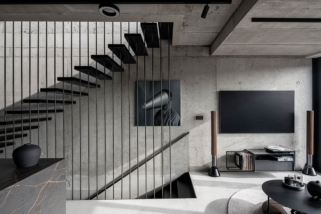 Modern living room with concrete walls and floating staircase design.
