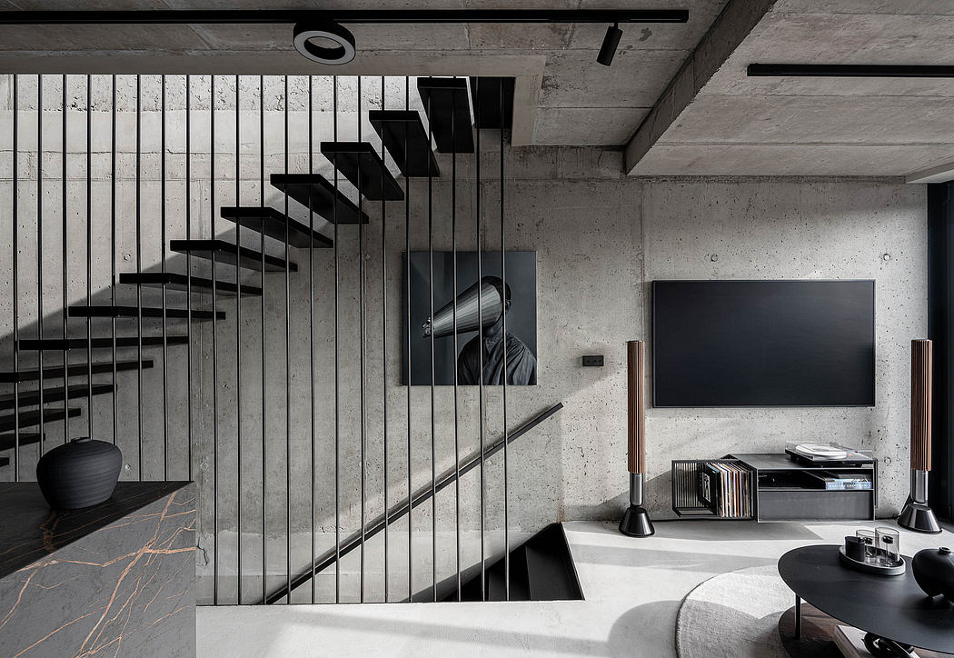 Modern living room with concrete walls and floating staircase design.
