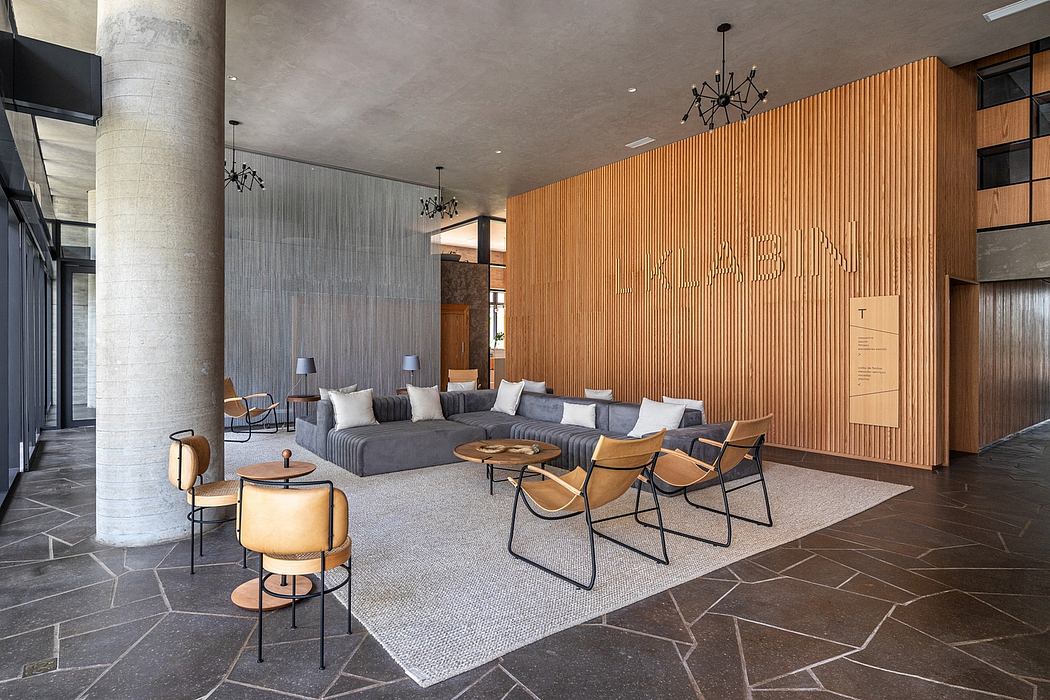 Modern lobby with sectional sofa, chairs, and wooden wall paneling.
